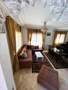 uma sala de estar com um sofá e um piano em Beautiful Villa Casablanca em Casablanca
