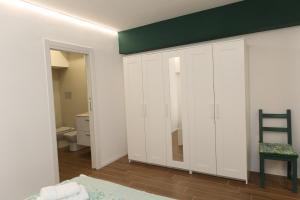 Schlafzimmer mit weißen Schränken und grüner Decke in der Unterkunft Piccina House in Cefalú