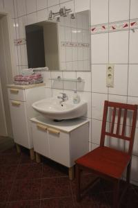 a bathroom with a sink and a chair and a mirror at Basislager Hohnstein - Familie Lösel in Ehrenberg