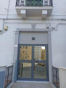 - une porte menant à un bâtiment avec un balcon au-dessus dans l'établissement Casa vacanze home cecilie, à Reggio de Calabre