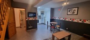 a living room with a kitchen with a table and a refrigerator at Maison de Luxe Centre ville avec 6 lits et Garage in Valenciennes