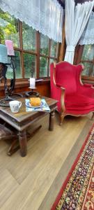 a living room with a red chair and a coffee table at 'T boshuisje in Opglabbeek