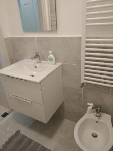 a bathroom with a white sink and a toilet at appartamento la pineta 10058-LT-0004 in Serra Riccò