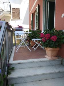 una mesa y sillas en un balcón con flores en appartamento la pineta 10058-LT-0004, en Serra Rocco