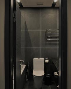 a bathroom with a toilet and a sink at TITA Family House in Gnedin