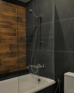 a bathroom with a shower and a bath tub at TITA Family House in Gnedin