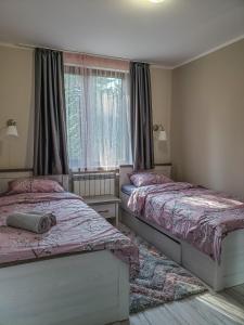 a bedroom with two beds and a window at Lovely Borovets Apartment in Borovets