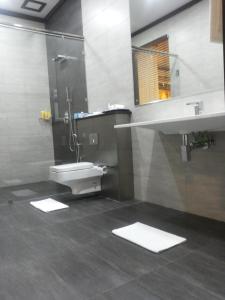 bagno con servizi igienici, lavandino e specchio di Blue Beach Hotel a Wadduwa
