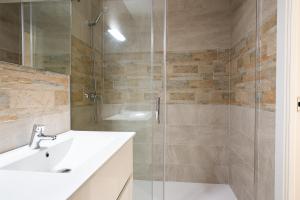 a bathroom with a sink and a glass shower at Apartamentos La Jasa in Arguedas