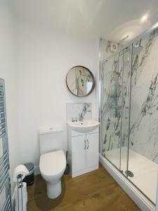 a bathroom with a toilet and a sink and a shower at Pearl House - Delightful 3-4 Bedroom Coastal Getaway in Gorleston-on-Sea