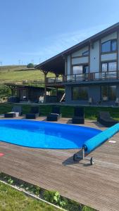 a house with a large swimming pool in front of it at TOPHILL House in Palyanytsya