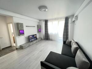 a living room with a couch and a flat screen tv at R&C Relax Apartment 808 in Dudu