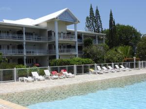 a resort with a row of chairs and a swimming pool at Le Mabouya in Saint-François