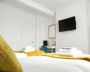 a bedroom with two beds and a flat screen tv on the wall at Kings Head Inn, Warwick in Warwick