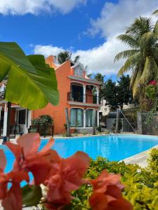 a villa with a swimming pool in front of a house at The Tourelle of Paradise with Big Heated Private Pool May-Aug in Rivière Noire