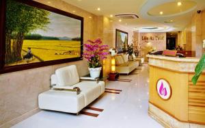 a lobby with white chairs and a painting on the wall at Lien An Sai Gon Hotel in Ho Chi Minh City