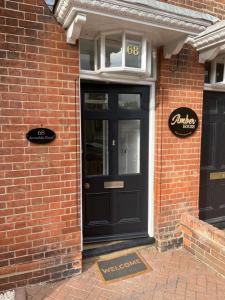 a black door on the side of a brick building at Pearl House - Delightful 3-4 Bedroom Coastal Getaway in Gorleston-on-Sea
