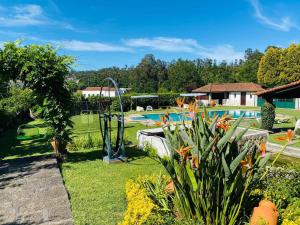a garden with a swimming pool and a playground at Casa dos Laceiras in Sandim