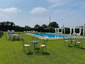 un grupo de mesas y sillas frente a una piscina en Casa dos Laceiras, en Sandim