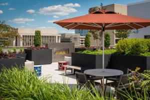 a patio with a table and a red umbrella at Stylish Condo at Crystal City With Rooftop in Arlington