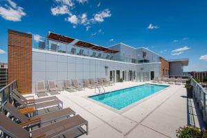 a swimming pool with chairs and a building at Stylish Condo at Crystal City With Rooftop in Arlington