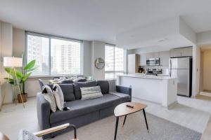 a living room with a couch and a kitchen at Stylish Condo at Crystal City With Rooftop in Arlington