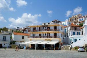 a large yellow building in front of a group of buildings at GEORGIOS L in Skopelos Town