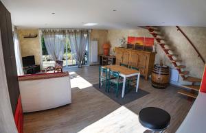 a living room with a staircase and a table and chairs at Élégante maison moderne en Ardennes françaises - Tout le confort pour un séjour mémorable in Renwez