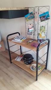 a shelf with a table with books on it at Le Ty Douar in Coëtmieux