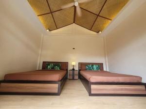 two beds in a room with a ceiling at VYU PRIVATE VILLA - TAGAYTAY in Tagaytay +9 photos