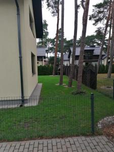 a fence in front of a house with trees at Willa nad morzem in Pobierowo