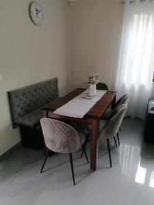 a dining room table with chairs and a clock on the wall at Willa nad morzem in Pobierowo