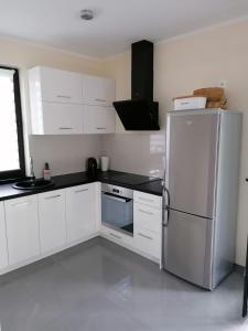 a kitchen with white cabinets and a refrigerator at Willa nad morzem in Pobierowo