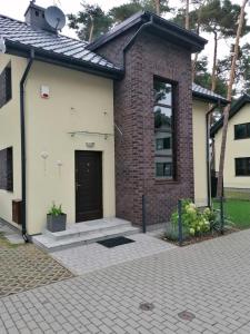 a brick house with a black door at Willa nad morzem in Pobierowo