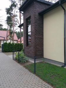 a brick house with a white garage at Willa nad morzem in Pobierowo