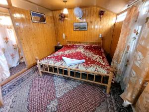Tashkand Houseboat في سريناغار: غرفة نوم صغيرة مع سرير في غرفة خشبية