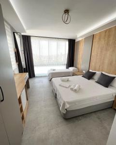 a bedroom with two beds and a large window at Luna Alacati in Alacati