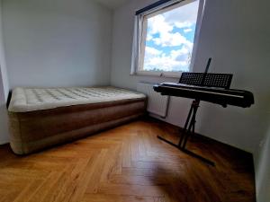 1 dormitorio con cama y escritorio con ordenador portátil en Piękny apartament położony w środku lasu, en Dywity
