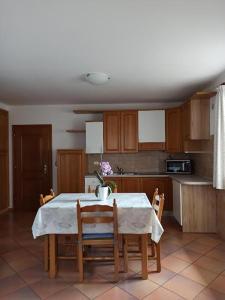 a kitchen with a table and some chairs and a table and a kitchen at Appartamento Emma in Molveno