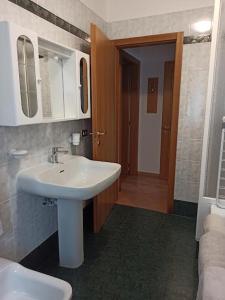 a bathroom with a white sink and a toilet at Appartamento Emma in Molveno
