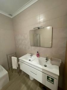 La salle de bains est pourvue d'un lavabo blanc et d'un miroir. dans l'établissement Alojamento S. Gabriel 1, à Monchique