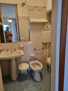 a bathroom with a toilet and a sink and a mirror at Condomino Giuditta in Porto Santa Margherita di Caorle