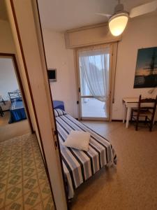 um quarto com uma cama e uma porta de vidro deslizante em Condomino Giuditta em Porto Santa Margherita di Caorle