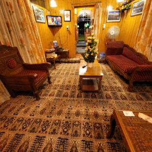 a living room with couches and a coffee table at Tashkand Houseboat in Srinagar