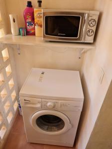 um micro-ondas e uma máquina de lavar roupa numa prateleira em Casa Lima em Múrcia