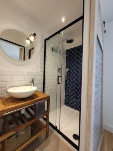 ein Bad mit einem Waschbecken und einer Glasdusche in der Unterkunft Domaine Mas de Galy in Saujac