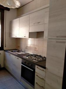 a kitchen with white cabinets and a stove top oven at Casa nel Delta del Po in Scardovari