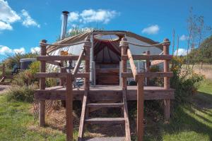 a wooden bed with a ladder next to a yurt at Little Oakhurst in Clitheroe