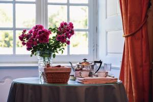einen Tisch mit einer Blumenvase auf dem Tisch in der Unterkunft Château de La Vigne in Ally