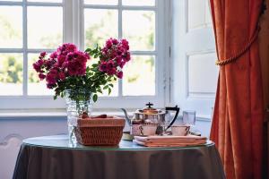 a table with a vase of flowers on a table at Château de La Vigne in Ally +46 photos
